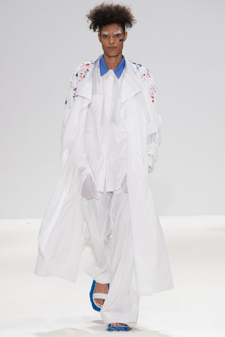 Catwalk image from CIMONE SS17 featuring model Vanessa David. Colourful embroidered paint splashes on crisp white cotton 'Helios' trench coat from emerging brand CIMONE. Embellishments and overall look at echoed by Oscar de la Renta one year later in SS18 - be ahead of the trends and support new brands!