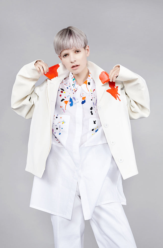 Colourful embroidered paint splashes on crisp white cotton 'cleave' shirt from emerging brand CIMONE. Embellishments and overall look at echoed by Oscar de la Renta one year later in SS18 - be ahead of the trends and support new brands! Worn with an orange rubberised paint drip collar version of out white cropped bomber - "flight jacket"