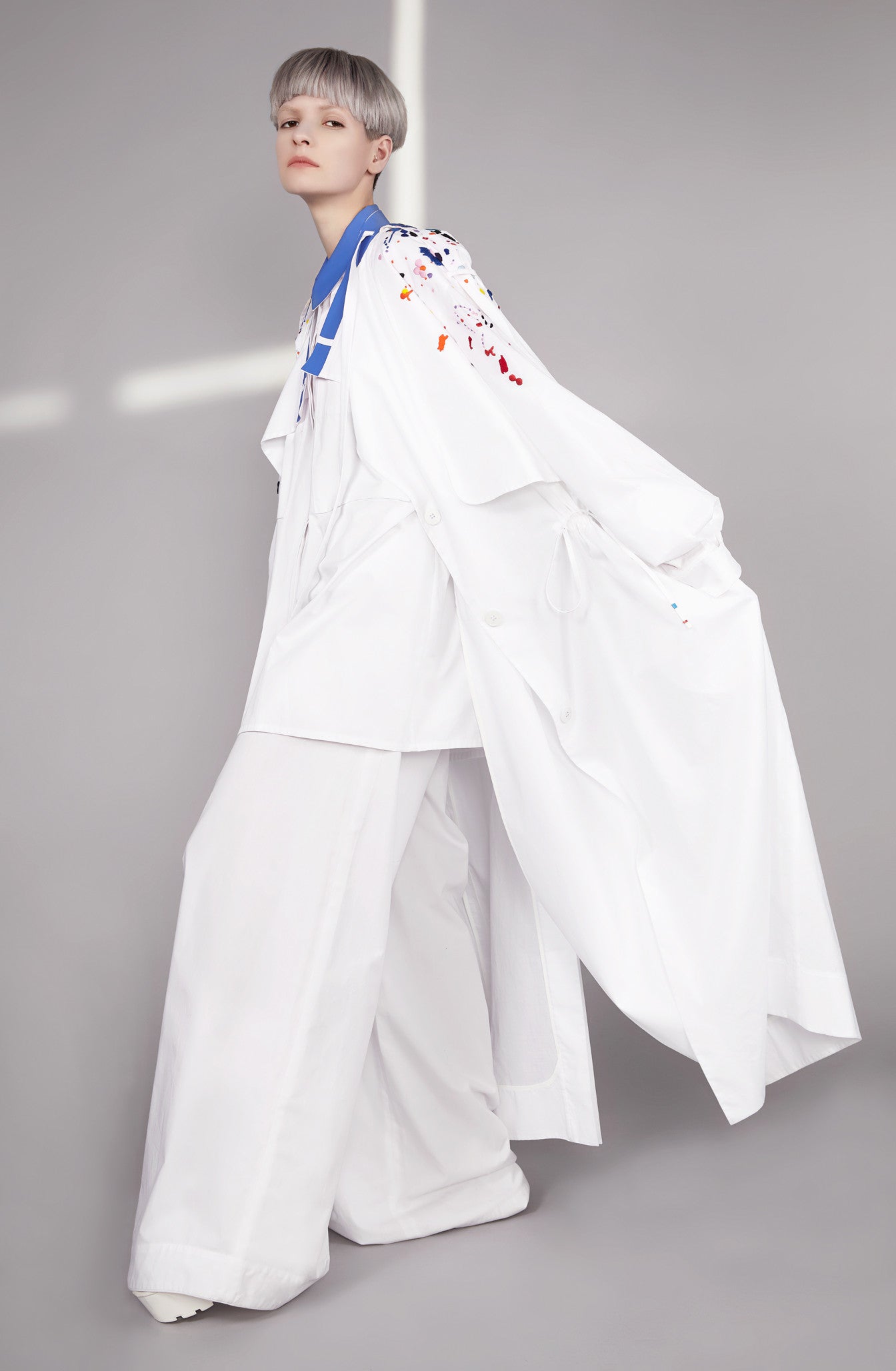 Colourful embroidered paint splashes on crisp white cotton 'Helios' trench coat from emerging brand CIMONE. Embellishments and overall look at echoed by Oscar de la Renta one year later in SS18 - be ahead of the trends and support new brands!