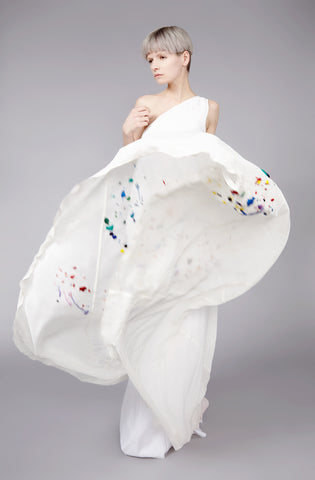 Embroidered one shoulder long dress sewn with bias cut sections of fabric to wrap around the body, allowing a slim top part and extra wide hemline. Embellished by beautiful multicoloured paint splash embellishments. 